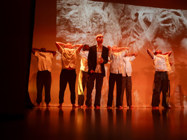 Young dancers on stage with a backdrop projected behind, reminiscient of the TURNING POINT films