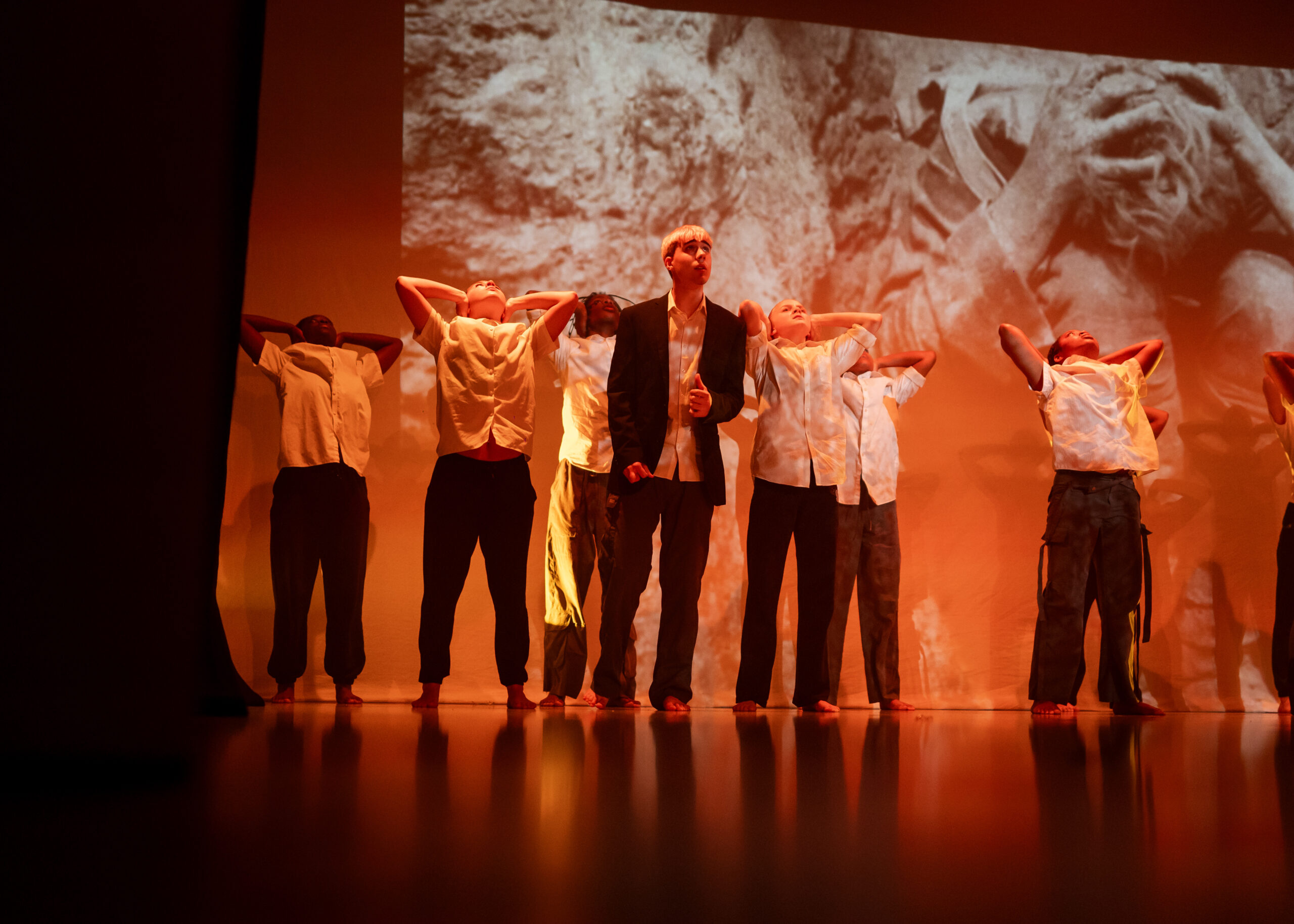 Young dancers on stage with a backdrop projected behind, reminiscient of the TURNING POINT films